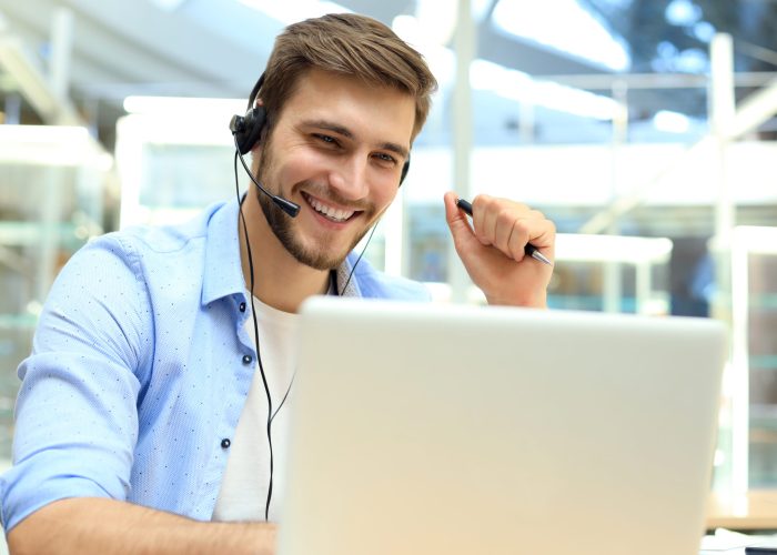 Happy young male customer support executive working in office